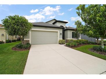 Charming single-story home with a well-manicured lawn and attached two-car garage at 2400 Pawtucket Pass, Mount Dora, FL 32757