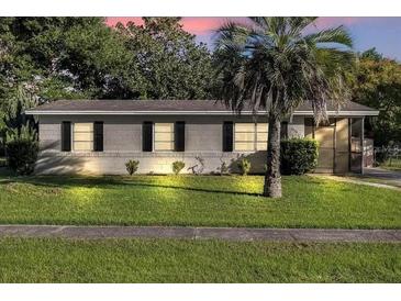 Charming single-story home with a well-maintained lawn, mature trees, and a palm tree in the front yard at 2433 Adams Ave, Deltona, FL 32738