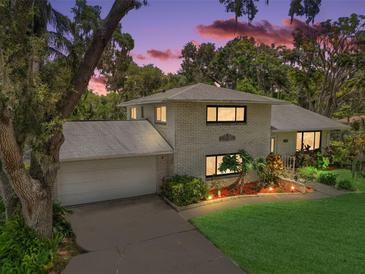 Charming two-story home with landscaped yard and attached garage, set against a beautiful sky at 27212 Orange Ave, Yalaha, FL 34797