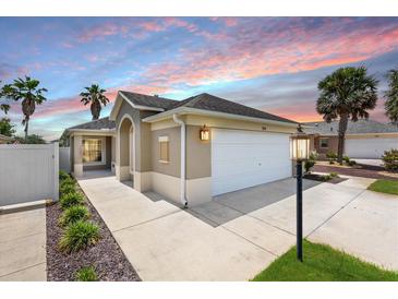 Charming single-story home featuring a two-car garage and well-maintained landscaping at 3331 Overland Ter, The Villages, FL 32163