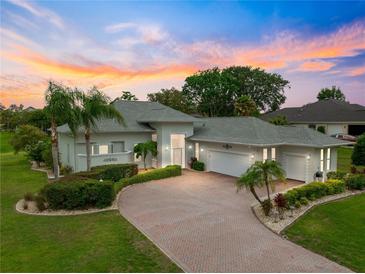 Beautiful single-story home featuring a brick driveway, manicured landscaping, and a two-car garage at 39145 Treeline Dr, Lady Lake, FL 32159