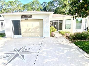 Charming home featuring a one-car garage and a unique compass design in the driveway at 409 Westwood Dr, Leesburg, FL 34748