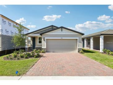 Charming one-story home featuring a brick driveway and two-car garage, beautifully landscaped at 4973 Kaia Ave, Winter Haven, FL 33884