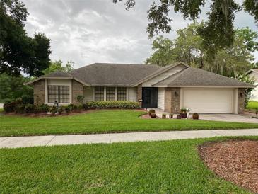 Charming single story home with a well maintained front yard and an attached two car garage at 724 Rosemere Cir, Orlando, FL 32835