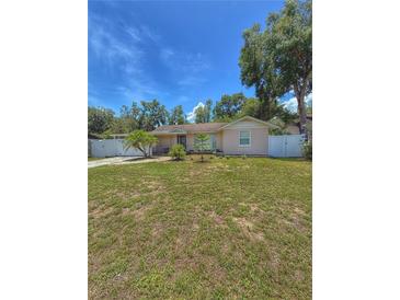 Charming single-story home with a well-maintained lawn and a white fence, offering a welcoming curb appeal at 100 W Idlewild Ave, Eustis, FL 32726