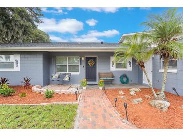 Charming front entrance with a beautiful wreath, cozy benches, and landscaped garden beds creates a warm and inviting welcome at 11750 Watts Ct, Tavares, FL 32778
