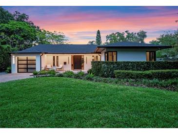 Charming single-story home featuring a well-manicured lawn, modern garage door, and an inviting entrance at 1237 Mercedes Pl, Orlando, FL 32804