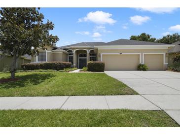 Attractive single-story home featuring a well-manicured lawn and a three-car garage at 1426 Lakemist Ln, Clermont, FL 34711