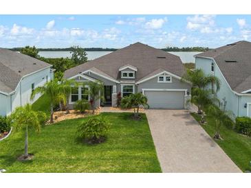 Charming single-story home with a well-manicured lawn, palm trees, and a brick driveway leading to a two-car garage at 2330 Nuthatch St, St Cloud, FL 34771