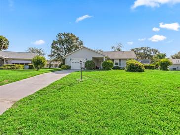 Charming single-story home with a well-manicured lawn and attached one car garage at 512 Galloway Ct, Leesburg, FL 34788