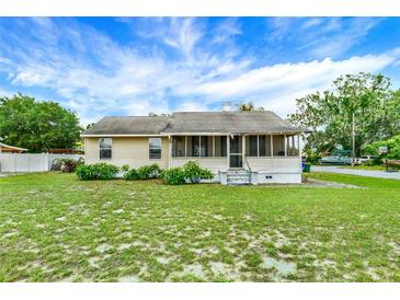 Charming single-story home with a screened porch and a well-maintained front yard at 520 Dora Ave, Tavares, FL 32778