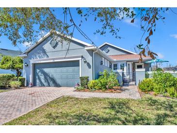Charming single-story home with a well-manicured lawn, brick walkway, and attached two-car garage at 109 Falling Acorn Ave, Groveland, FL 34736