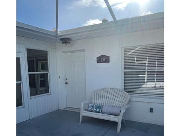 Charming front porch with a cozy bench, perfect for enjoying the neighborhood view at 1105 Hazelnut Dr, Leesburg, FL 34748