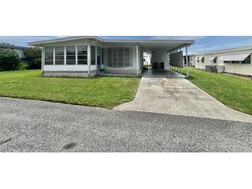 Charming single-story home featuring a covered carport and well-maintained lawn at 112 Caladium St, Leesburg, FL 34748