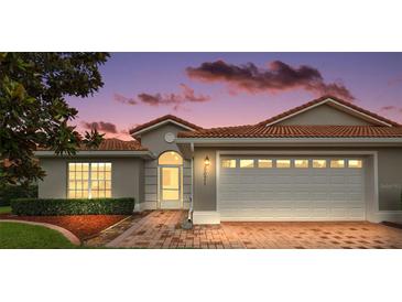 Charming single-story home with a red tile roof, brick driveway, and manicured landscaping at 5071 Harbour Dr, Oxford, FL 34484