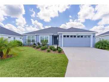 Charming single Gathering home boasting a well maintained lawn, mature plantings and a two car garage at 6949 Minchew Cir, The Villages, FL 34762