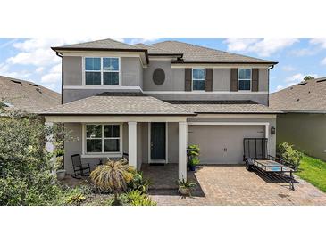 Charming two-story home with a well-manicured front yard and inviting covered entry at 9153 Carmela Ave, Davenport, FL 33897