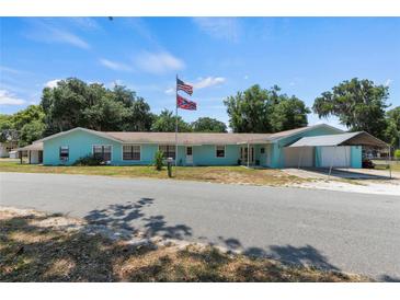 Charming single story home with a covered attached carport and manicured lawn at 1048 Cr 452A, Lake Panasoffkee, FL 33538