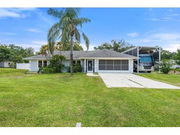Charming single-story home with well-maintained lawn, mature landscaping, and spacious driveway at 135 N James Pl, Groveland, FL 34736