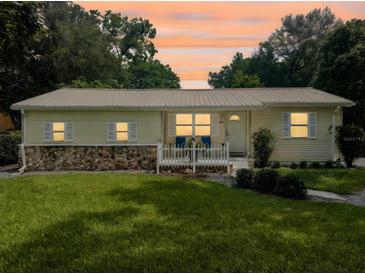 Charming single-story home with well-maintained lawn and front porch seating under a beautiful sunset sky at 1537 Ne 22Nd St, Ocala, FL 34470