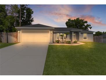 Charming single-story home with a well-manicured lawn, two-car garage, and inviting curb appeal at 15828 Se 98Th Ter, Summerfield, FL 34491