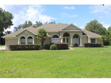 Charming single-story home featuring a well-manicured lawn and arched entryway at 31104 Fairvista Dr, Tavares, FL 32778