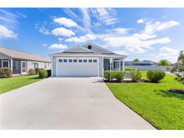 Charming single-story home with a well-manicured lawn, two-car garage, and inviting curb appeal on a sunny day at 3283 Dawn Pl, The Villages, FL 32163