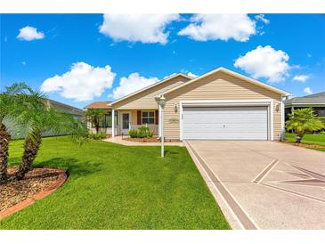 Charming single-story home with a well-manicured lawn, decorative driveway, and attached two-car garage at 362 Arbella Loop, The Villages, FL 32162