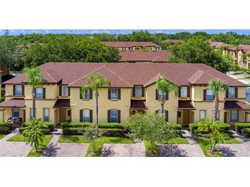 Inviting townhome exterior featuring a well-maintained lawn and lush landscaping at 624 Terra Lago St, Davenport, FL 33897