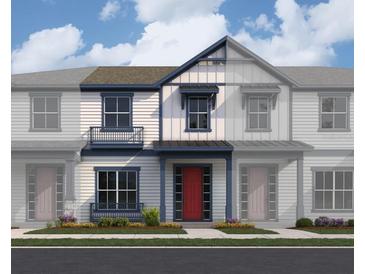 Charming townhome showcases a classic design with a red front door, complemented by stylish blue trim and a cozy front porch at 6527 Trailblaze Bnd, St Cloud, FL 34771
