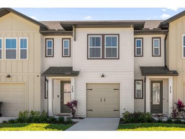 Charming townhouse with neutral siding, a one-car garage, and well-manicured landscaping at 709 Longboat Dr, Davenport, FL 33896