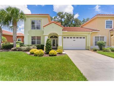Charming two-story home with a well-manicured lawn, lush landscaping, and a two-car garage at 1055 Avenida Sonoma, Lady Lake, FL 32159