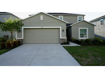 Two-story home featuring an attached two-car garage, neutral paint, and simple landscaping at 1138 Calico Pointe Cir, Groveland, FL 34736