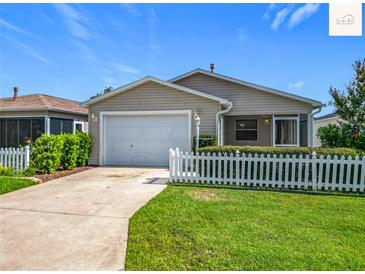 Charming single-story home with a well-maintained lawn and white picket fence at 2311 Pine Ridge St, The Villages, FL 32162