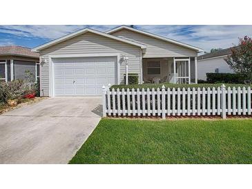 Charming home featuring a one-car garage, screened porch, and a classic white picket fence at 2311 Pine Ridge St, The Villages, FL 32162