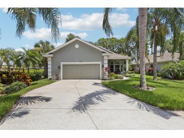 Charming home with a two-car garage, mature palm trees, and a well-manicured lawn at 2512 Baywater Rd, Tavares, FL 32778