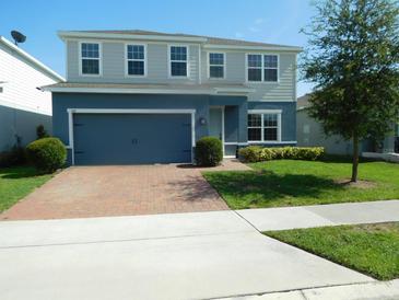Two-story home featuring a brick driveway and landscaped front yard, offering classic curb appeal at 418 Winter Bliss Ln, Mount Dora, FL 32757