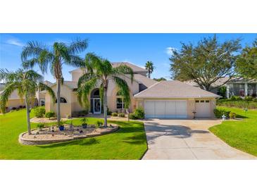 Charming home featuring a well-manicured lawn, palm trees, and a spacious three-car garage at 5740 Bounty Cir, Tavares, FL 32778