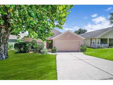 Charming single-story home featuring a well-maintained lawn and a two-car garage at 1055 Bluegrass Dr, Groveland, FL 34736