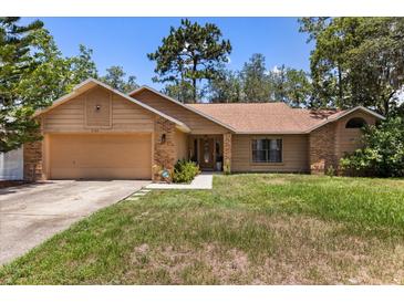 Charming single-story home featuring a brick facade, well-manicured lawn, and attached two-car garage at 3184 Maltby Dr, Deltona, FL 32738