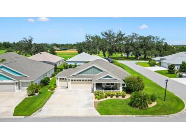 Charming single-story home with a manicured lawn, covered porch, and three-car garage at 5311 Eads Ter, The Villages, FL 32163