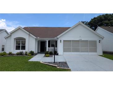 Charming home featuring a well-manicured lawn and a convenient two-car garage at 1105 San Remo Ln, Lady Lake, FL 32159