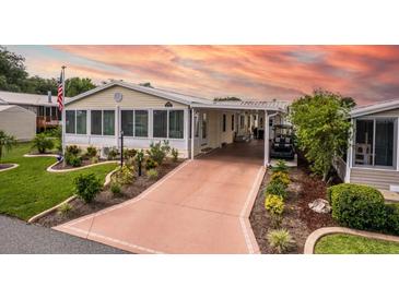 Well-maintained single-story home with a covered carport and lovely landscaped front yard at 11926 Milan Way, Leesburg, FL 34788