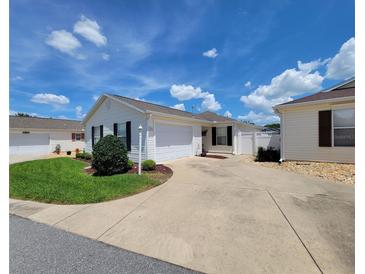 Charming single-story home featuring a well-maintained lawn and a spacious driveway leading to an attached garage at 17695 Se 84Th Peyton Ct, The Villages, FL 32162