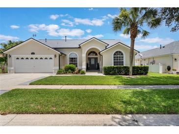 Charming single-story home with a well-manicured lawn, arched windows, and a welcoming front entrance at 3128 Ibis Hill St, Clermont, FL 34714