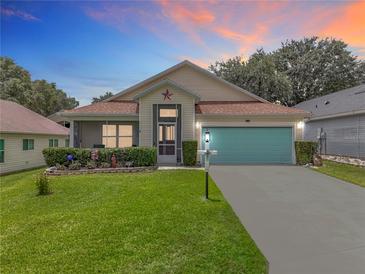 Charming single-story home featuring a well-manicured lawn and a bright blue garage door at 4520 Eaglewood Dr, Leesburg, FL 34748