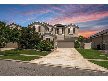 Charming two-story home featuring a well-maintained lawn and a long driveway leading to an attached garage at 12120 Sumter Dr, Orlando, FL 32824