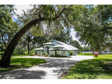 Charming single-story home with mature trees and manicured lawn on a sprawling lot at 168 Pond Rd, Mount Dora, FL 32757