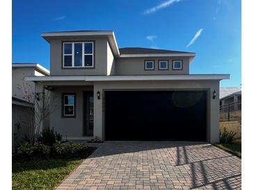 Beautiful two-story home with a two car garage and paver driveway on a sunny day at 2064 Asher Ave, Minneola, FL 34715
