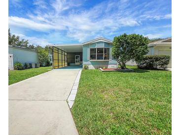 Charming blue home with well-maintained lawn and carport, perfect for easy parking at 32339 Oak Park Dr, Leesburg, FL 34748